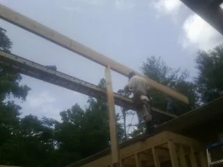 Carpenter setting a ridge beam over a new addition frame — Ice Dam Removal by Roofing Brothers in Mattaponi