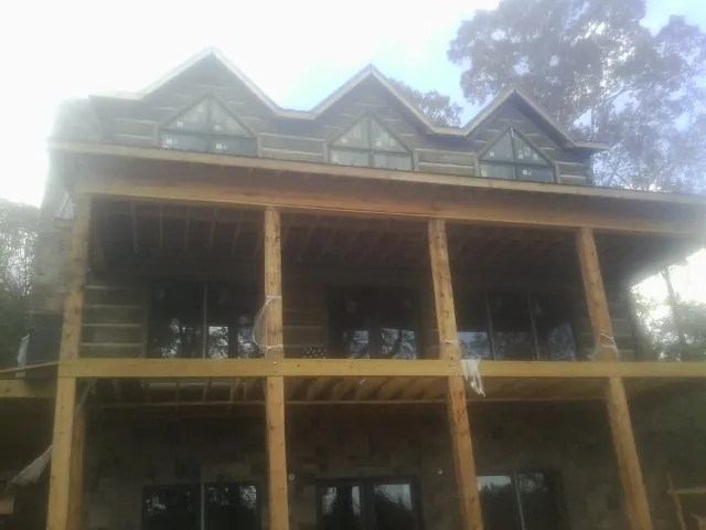 Dormers and porch framing on a large log home under construction — Roof Coating work by our crew in Mattaponi