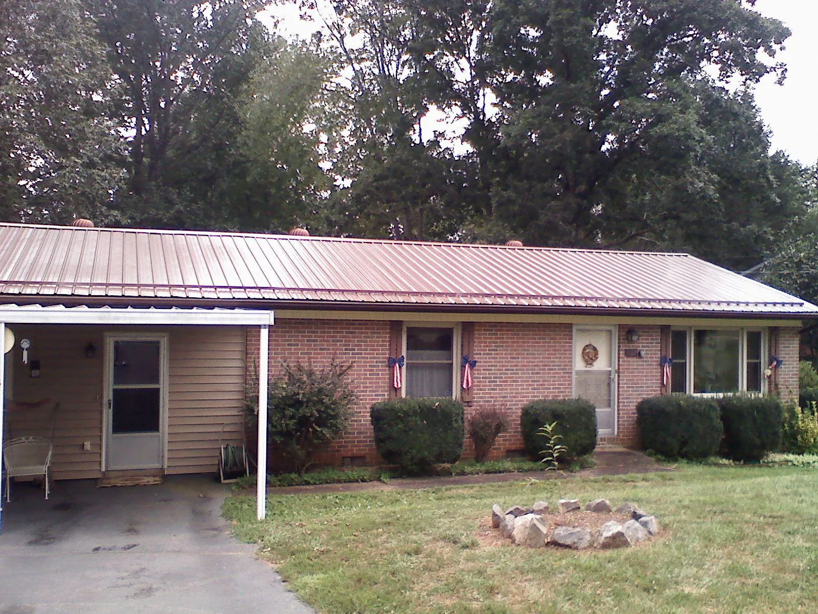 Bronze metal roof and carport on a brick ranch home — Roof Repair work by our crew in Mattaponi